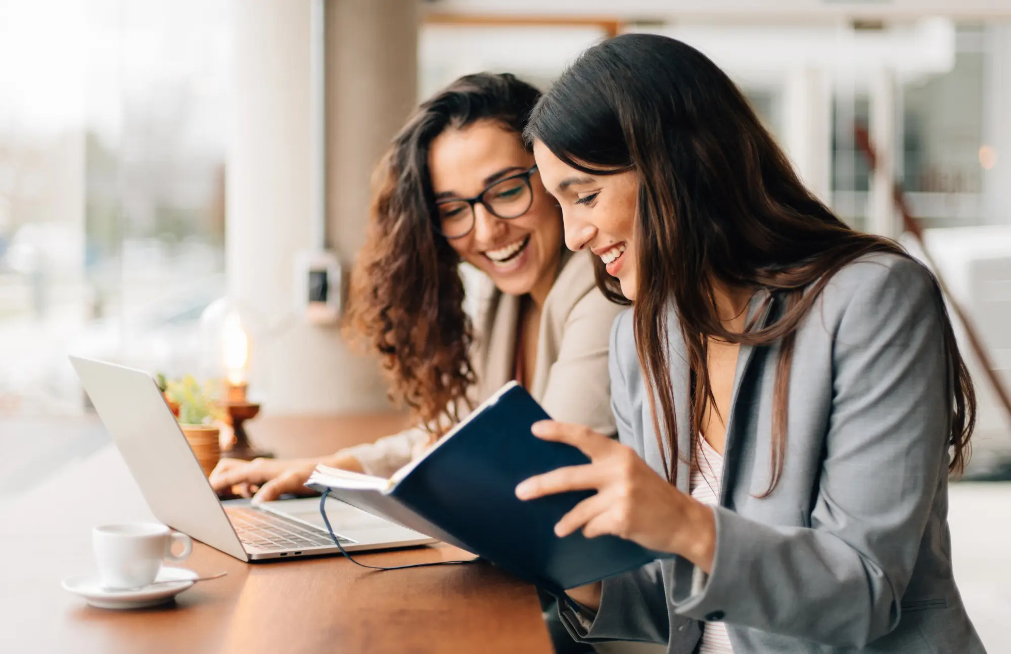 two women looking at notes on a desk
